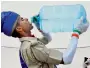  ?? PTI ?? A newly inducted provincial armed constabula­ry personnel quenching his thirst after passing out parade in Moradabad. —