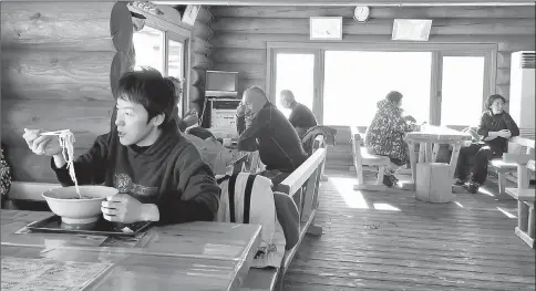  ??  ?? Skiers and snowboarde­rs take a lunch break at the lodge atop Charmant Hiuchi, a two-lift ski area near Itoigawa, Japan. Ramen adorned with fresh vegetables, meat and seafood is a staple on lunch menus throughout Japan’s ski country. — The Washington...