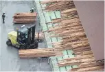  ??  ?? Workers sort and move lumber at a cedar sawmill in Delta.