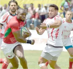  ??  ?? Kenya’s Ambaka (left) runs with the ball as Tunisia’s player Mohammed Achref Dhif (right) attempts to block him during the 2019 Rugby World Cup Africa qualifier match between Kenya and Tunisia, in Nairobi. — AFP photo