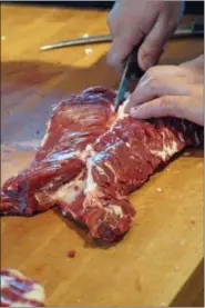  ?? PHOTO BY EMILY RYAN — FOR MEDIANEWS GROUP ?? A butcher trims hanger steak.