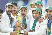  ?? GETTY IMAGES ?? Pakistan captain Sarfraz Ahmed and team with the Champions Trophy after beating India in London on June 18.