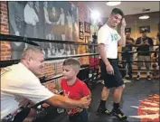  ?? Christina House Los Angeles Times ?? MIKEY GARCIA, right, and his brother, Robert, get a visit from Mikey’s 3-year-old son, Django, during a recent workout at Fortune Gym in Hollywood.