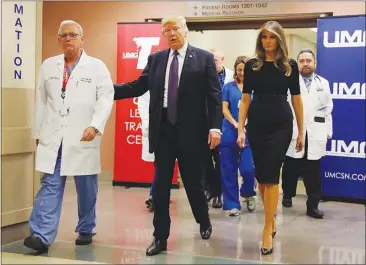  ?? EVAN VUCCI / AP ?? President Donald Trump and first lady Melania Trump walk Wednesday with surgeon Dr. John Fildes at University Medical Center. The president and first lady were in Las Vegas for part of the day to meet with survivors of Sunday’s mass shooting and to...