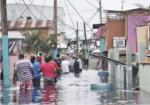  ??  ?? ► Puertorriq­ueños caminan por la barriada de Juana Matos, en Puerto Rico.