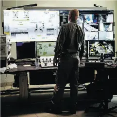  ?? TYLER ANDERSON / NATIONAL POST ?? An employee remotely monitors mining operations inside a Goldcorp control room.