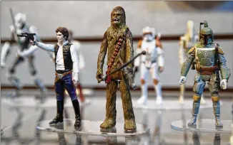  ?? SETH WENIG / AP 2014 ?? Figurines from the popular “Star Wars” movie franchise are on display at a Hasbro showroom in New York. The toymaker saw slower sales in the fourth quarter.