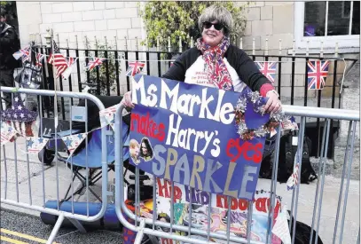  ?? Alastair Grant ?? The Associated Press American royal fan Donna Werner, who came over to Britain specially for the upcoming royal wedding of Britain’s Prince Harry and Meghan Markle, shows off her placards in her position along the carriage route Wednesday in Windsor,...