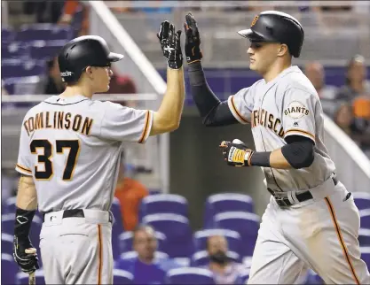  ?? LYNNE SLADKY — THE ASSOCIATED PRESS ?? The Giants’ Ryder Jones, right, is high-fived by Kelby Tomlinson after hitting a solo home run during the eighth inning of the Giants’ 9-4win against the Miami Marlins on Tuesday in Miami. Tomlinson finished 2for 4, including a single that started a...