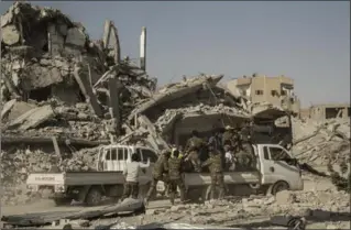  ?? ASMAA WAGUIH, THE ASSOCIATED PRESS ?? The U.S.-backed Syrian Democratic Forces ride near the main traffic circle in Raqqa, Syria, Friday. The SDF declared from the stadium the “total liberation” of Raqqa, the capital of the Islamic State for more than three years.