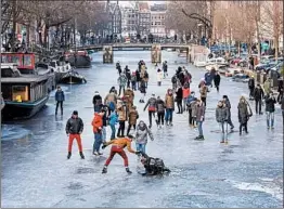  ?? EVERT ELSINGA/EPA ?? Nobody complained about the cold Friday at Amsterdam’s Prinsengra­cht canal, which was thick enough for residents to glide across. Tourists to the Netherland­s took selfies.