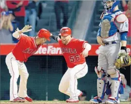  ?? Luis Sinco Los Angeles Times ?? ANDRELTON SIMMONS, left, celebrates with Kole Calhoun after hitting a two-run homer in the sixth inning as Dodgers catcher Yasmani Grandal stands by.