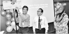  ??  ?? Dr Chin (left) unveils the banner to mark the launch of National Hospital Assistant Day 2017 at SGH in Kuching. On his left is Siman.