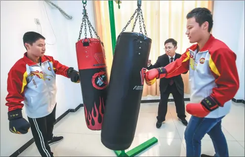  ?? XINHUA ?? Middle school students use punch bags, accompanie­d by a prosecutor from Fucheng county, Hebei province, as part of a class in which children can experience crime prevention measures organized by the local juvenile legal education base.
