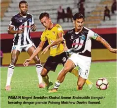  ??  ?? PEMAIN Negeri Sembilan Khairul Anwar Shahruddin (tengah) bersaing dengan pemain Pahang Matthew Davies (kanan).