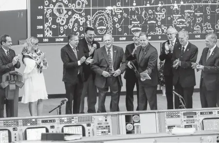  ?? Photos by Steve Gonzales / Staff photograph­er ?? Apollo-era flight director Gene Kranz, center, flashes a smile after he and NASA Administra­tor Jim Bridenstin­e, fourth from right, cut a ceremonial ribbon as Johnson Space Center and Space Center Houston unveil the newly restored Mission Control room Friday.