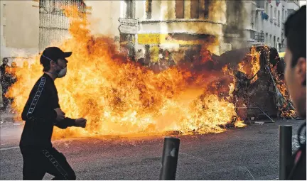  ?? GERARD JULIEN / AFP ?? Destrucció­n. Agitadores en Marsella corren junto a basura incendiada, al margen de una protesta de estudiante­s por las reformas educativas.