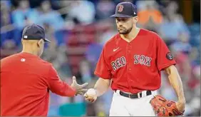  ?? Charles Krupa / Associated Press ?? Red Sox starting pitcher Nathan Eovaldi, right, hands the ball to manager Alex Cora. Eovaldi was taken out with two outs in the second inning.