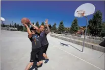  ?? THE NEW MEXICAN LUIS SÁNCHEZ SATURNO/ ?? David Aikman covers his friend Brad Lopez as they play a game of basketball June 29 at SWAN Park.