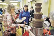  ?? [THE OKLAHOMAN ARCHIVES] ?? Chocolate Festival participan­ts dip tidbits into a chocolate fountain. This year’s festival will be Jan. 28.