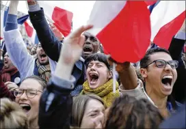  ?? LAURENT CIPRIANI / AP ?? Supporters of French independen­t centrist presidenti­al candidate Emmanuel Macron react outside the Louvre in Paris on Sunday after an election results announceme­nt projected Macron as France’s next president.