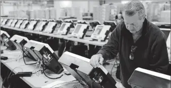  ?? [JOSHUA A. BICKEL/DISPATCH] ?? Scott Thomas, a logistics technician, prepares to boot up new voting machines at the Franklin County Board of Elections office on Morse Road on the Northeast Side.