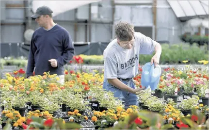  ?? PHOTOS BY STAN CARROLL/THE COMMERCIAL APPEAL ?? Gene, a resident at The Baddour Center, waters flowers in the recently relocated Garden Center on the grounds of the Senatobia campus. The center, in an area at the rear of the campus with a dedicated entrance off of Woolfolk Road, had its offi cial...