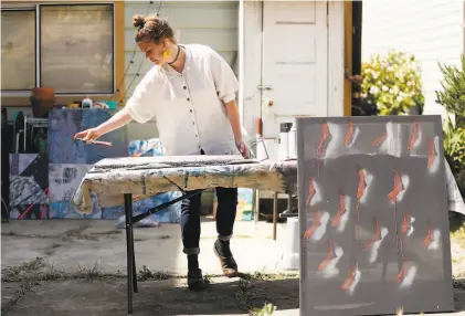  ?? Photos by Scott Strazzante / The Chronicle ?? Amy Lange, of SFMOMA and Borderline Collective, works on artwork, above, and sits in the backyard of her S.F. home, left. She is also a former server at Petit Crenn in S.F.