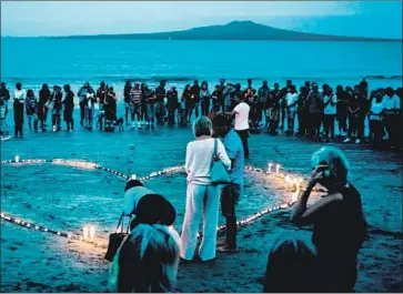 ?? Cam McLaren Getty Images ?? IN AUCKLAND, crowds gather on Takapuna Beach for a vigil in memory of the victims. A witness to the shooting at Linwood Mosque described a hero who confronted the attacker and grabbed his weapon.