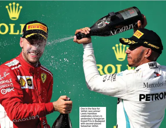  ??  ?? One in the face for Vettel: race winner Lewis Hamilton celebrates victory in yesterday’s Hungarian Grand Prix in Budapest with second-placed Sebastian Vettel.