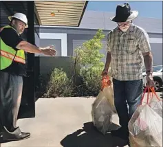  ??  ?? STEVE LOPEZ brings two weeks’ worth of recyclable­s to the Athens plant. He’s greeted by assistant general manager Johnny Stevenson.