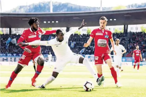  ?? KEYSTONE ?? Die Zürcher haben den Abstiegska­mpf angenommen: Assan Ceesay (M.) setzt sich gegen zwei Sittener durch.