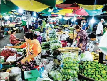  ?? SAHIBA CHAWDHARY ?? Vendors prepare stalls for selling fresh vegetables and fruits at Phnom Penh's Phsar Doeum Kor Market.