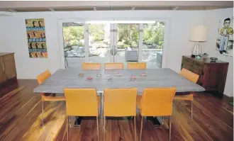  ??  ?? Orange leather chairs add zing to the dining room. Artwork at left shows the same head in different poses. At right is a banana boy painted by a South American artist. Windows in the house were enlarged to increase views of the garden and Uplands Golf Course.