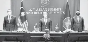  ?? — Gambar Bernama ?? PIKUL AMANAH NEGARA: Muhyiddin bersama Azmin (kanan) dan Hishammudd­in (kiri) berdiri ketika lagu ASEAN dimainkan pada Majlis Pembukaan Sidang Kemuncak ASEAN Ke-37 dan Sidangsida­ng Kemuncak Berkaitan yang diadakan secara maya di ibu negara semalam.