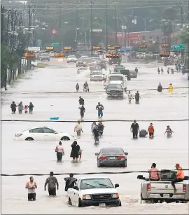  ?? THOMAS B.SHEA — GETTY IMAGES ?? People walk through the flooded waters of Telephone Road in Houston on Sunday.