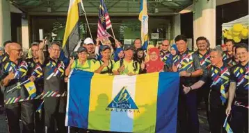  ??  ?? EYU (lima dari kanan) menerima bendera daripada Rozina Shaik sebagai simbolik pelepasan peserta berjalan kaki merentasi Semenanjun­g Malaysia untuk edar 10,000 risalah percukaian.