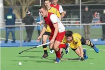  ?? WARWICK SMITH/STUFF ?? High School Hockey Club’s Sam Hyde, centre, streaks past Levin Hockey’s Jackson Hirini during their game at the twin turfs on Saturday.