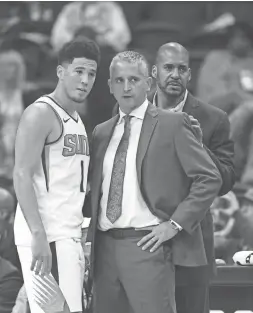  ??  ?? Suns guard Devin Booker (left) talks with coach Igor Kokoskov during a game against the San Antonio Spurs at Talking Stick Arena Wednesday night. The Suns won 116-96.