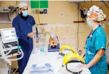  ?? AFP ?? Dr. Laher and Dr. Du Plessis demonstrat­e how to use an intubox.
Doctors across South Africa are bracing for a potential surge in critically ill patients as the number of infections continues to rise.