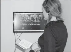  ?? SARAH SAUNDERS/SPECIAL TO THE GUARDIAN ?? Ruth Skinner checks out “The Precarious Creative Workers of the World Little Red Songbook” in the “Work/Shift” exhibition.