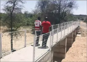  ??  ?? Zimbabwe Red Cross Society officials assess Khahlu footbridge in Mangwe district