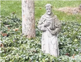  ?? ELLEN NIBALI/FOR THE BALTIMORE SUN ?? A garden statue of St. Francis stands in front of a hawthorn tree trunk.
