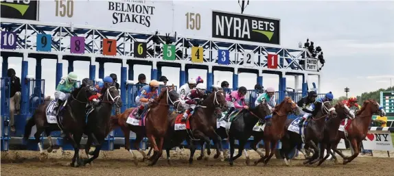  ?? AP FIle PHotos ?? AND THEY’RE OFF! Horses break from the starting gate at the 150th running of the Belmont Stakes at Belmont Park in Elmont, N.Y. in 2018. Justify, with jockey Mike Smith, crosses the finish line to win that race.
