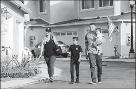  ?? Irfan Khan Los Angeles Times ?? ALICIA ESPINOZA, her husband, Bryan, and their two children walk around the Santa Clarita community where their home should be ready around March.