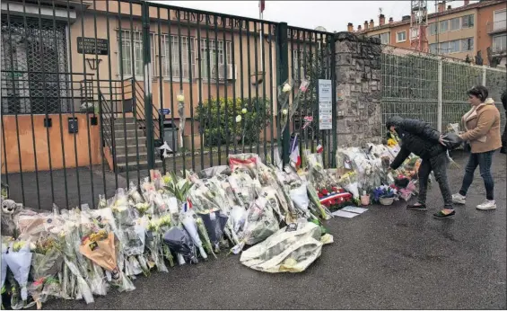  ?? / EMILIO MORENATTI (AP) ?? Una mujer deposita ayer un ramo de flores ante el cuartel general de la policía de Carcasona.