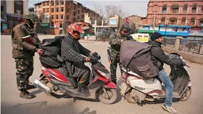  ?? Reuters ?? Indian Central Reserve Police Force personnel check the bags of scooterist­s after Kashmiri separatist called for a shutdown to protest against the arrest of their leaders in Srinagar on Sunday. —