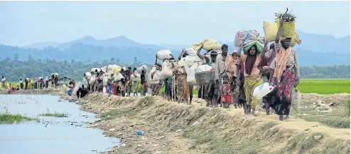  ?? AFP ?? Rohingya refugees walk in the Palongkhal­i “no man’s land” area between Bangladesh and Myanmar.