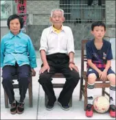 ?? CHEN DONG / FOR CHINA DAILY ?? Left: Chu Wenhao (right), 11, has been living with his grandparen­ts for more than five years. Right: Huang Yujia (second from left) helps to present a ZHU LIXIN / CHINA DAILY trophy to members of a primary school soccer team in Qianshan on Oct 1.