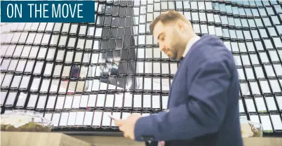  ?? Picture: Bloomberg ?? An attendee uses his mobile device as he stands in front of a display of mobile phones forming a mosaic on the second day of the Mobile World Congress in Barcelona, Spain, yesterday. The theme this year at the industry’s annual get-together, which ends...